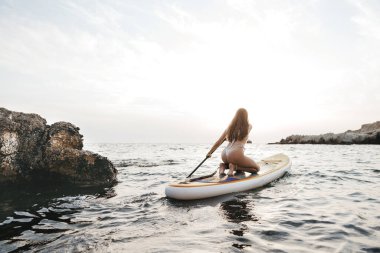 Güzel bir model, temiz suyla denizde dinleniyor.