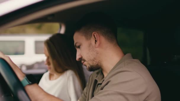Jovem casal sentado em um carro com janelas abertas, vista de dentro — Vídeo de Stock