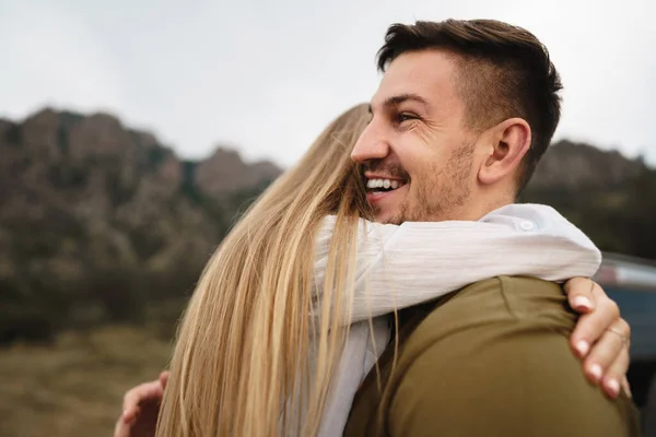 Happy loving couple hiking and hugging in mountains — Stock Photo, Image