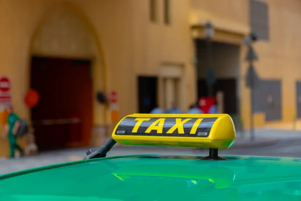 Panneau de taxi sur le toit d'une voiture dans une rue — Photo