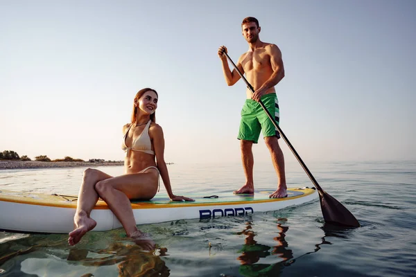 カップルの観光客若い男と女楽しいパドルボードで海 — ストック写真