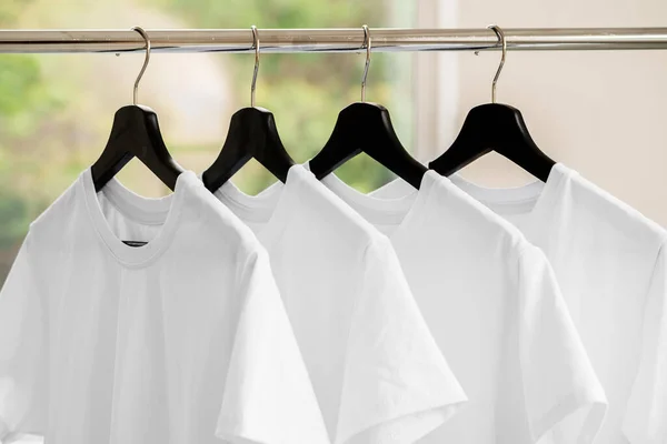 Rangée de t-shirts blancs sur cintres sur rack — Photo