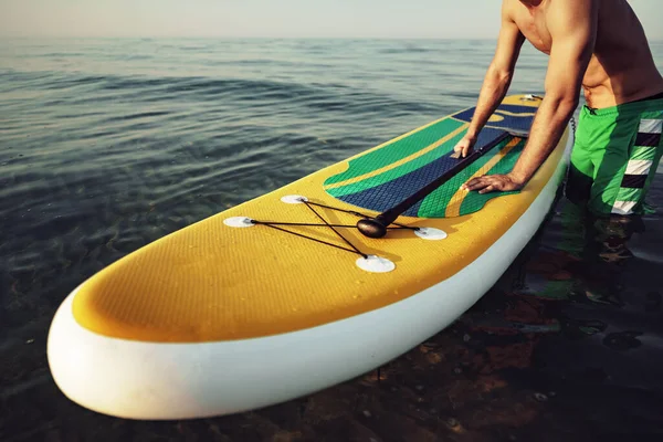 Young fit man on paddle board floating on lake. — Stock Photo, Image
