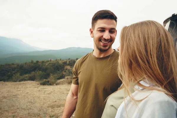 Young couple on trip relaxing and enjoying the view of mountains — Stock Photo, Image