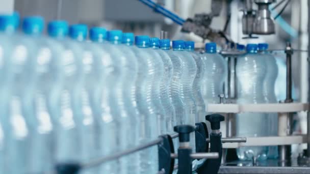 Botellas de agua que se mueven en la línea transportadora automática en la fábrica de producción de agua — Vídeos de Stock