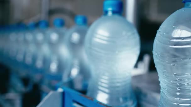 Vattenflaskor rör sig på automatisk transportör linje i vattenproduktion fabrik — Stockvideo