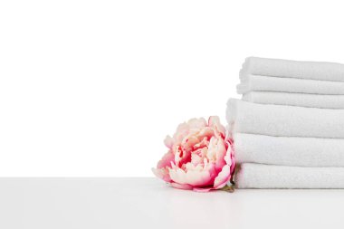Beyaz üzerinde izole havlular ve çiçekler bulunan spa kompozisyonu