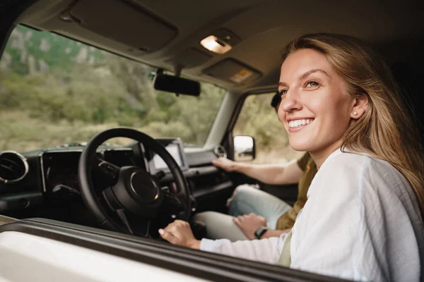 Schönes junges Paar sitzt auf Beifahrersitz und fährt Auto — Stockfoto