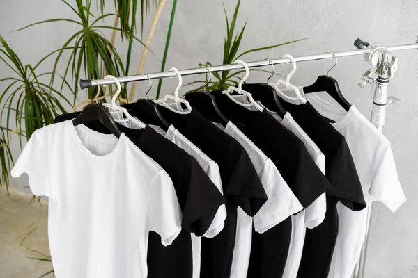 Rangée de t-shirts noirs et blancs suspendus sur rack — Photo