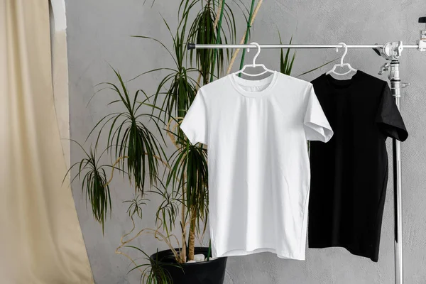 White and black T-shirts on hangers for design presentation — Stock Photo, Image
