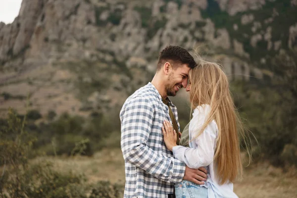 Feliz pareja cariñosa senderismo y abrazos en las montañas — Foto de Stock