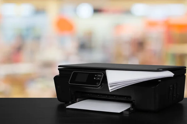 Impressora a laser compacta em mesa preta contra fundo desfocado — Fotografia de Stock