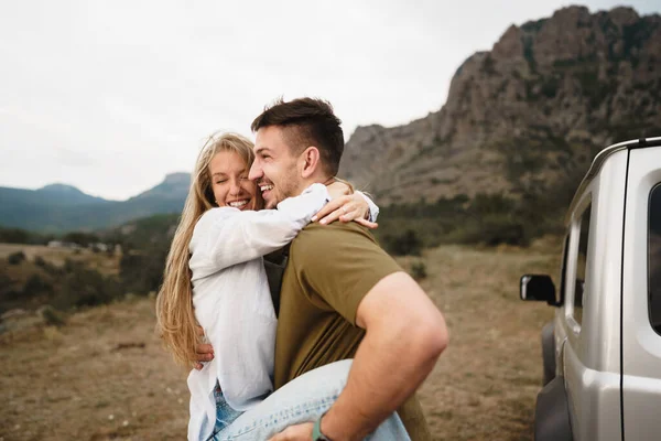 Pareja joven está en viaje romántico a las montañas en coche — Foto de Stock