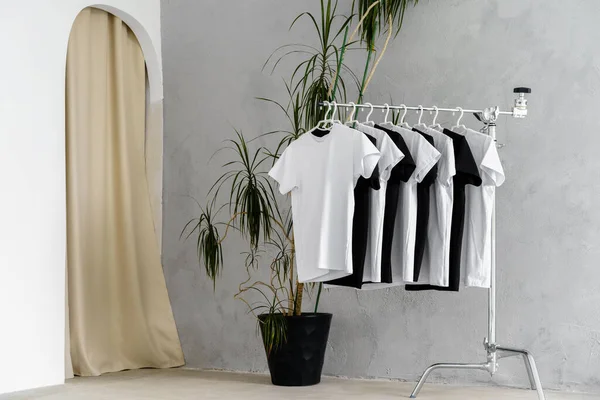 Rangée de t-shirts noirs et blancs suspendus sur rack — Photo