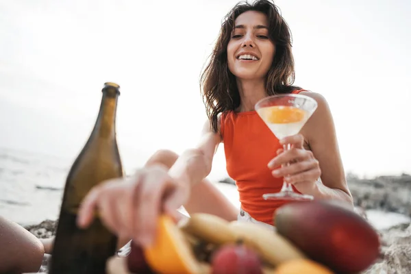 Retrato de uma jovem com um copo de cocktail a arrefecer numa praia — Fotografia de Stock