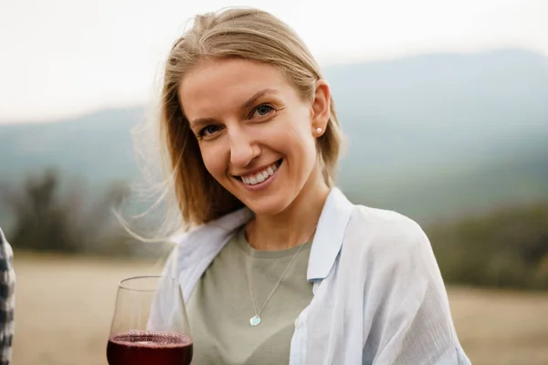 Hermosa hembra joven con una copa de vino tinto en las montañas — Foto de Stock