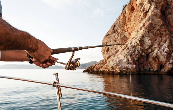 外洋の帆船で釣りをしながら釣竿を持つ男性の手の閉じる — ストック写真