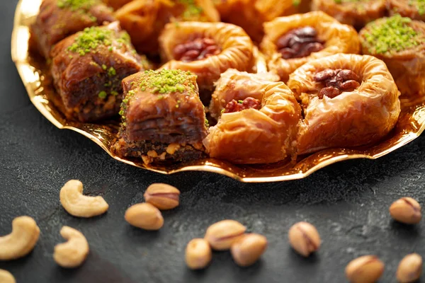 Delicioso postre de baklava en ambiente oriental sobre fondo negro — Foto de Stock