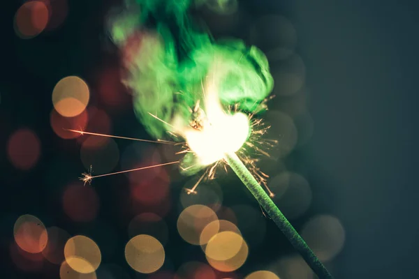 Close-up of green holiday sparkler in the dark — Stock Photo, Image