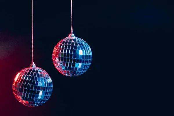 Ігристі диско-кулі висять у повітрі на чорному тлі — стокове фото