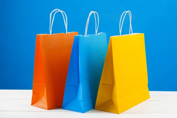 Sacos de compras de papel com espaço de cópia no fundo azul — Fotografia de Stock