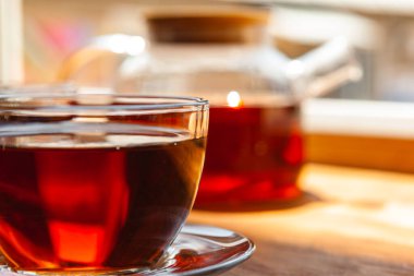 Sıcak bir fincan çay, ahşap kırsal masada.