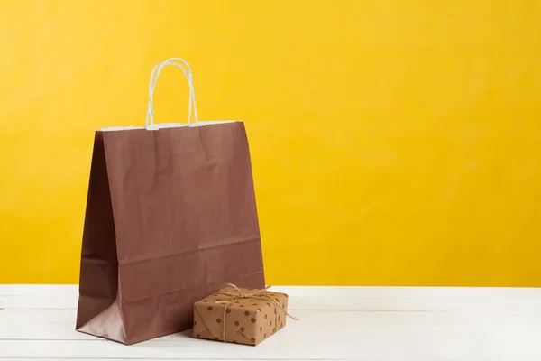Arranjo de sacos de compras no fundo amarelo brilhante — Fotografia de Stock
