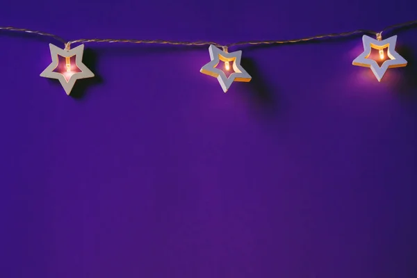 Beleuchtete sternförmige Girlande auf farbigem Hintergrund Nahaufnahme — Stockfoto