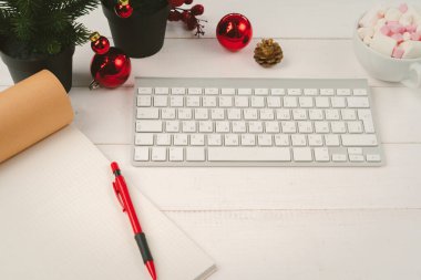 Masadaki dizüstü bilgisayarı ve defteri noel dekoruyla aç