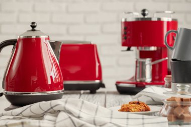 Mutfak rafında kırmızı çatal bıçak ve bulaşık takımı var.