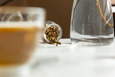 Kuru çay yapraklı cam kavanozlar beyaz masaya yakın.