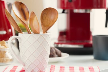 Mutfak gereçleri bardakta, masaya yakın.