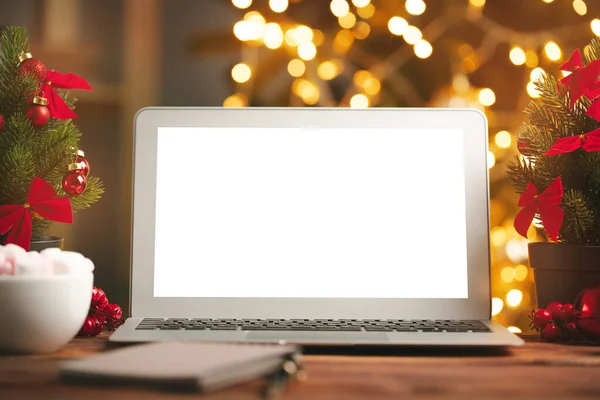 Drewniane biurko z komputerem z czystym ekranem na tle rozmytych świateł Bożego Narodzenia — Zdjęcie stockowe