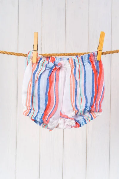 Wassen van babykleding vastgepind aan een touw om te drogen — Stockfoto