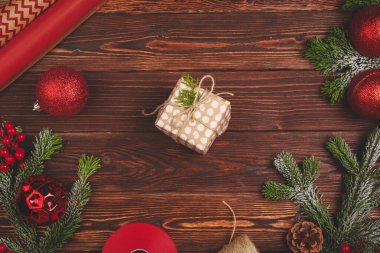 Ahşap arka planda kurdeleyle süslenmiş şık bir Noel hediyesi.