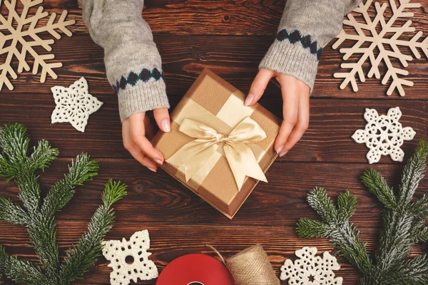 Mujer sosteniendo regalo de Navidad envuelto en sus manos, vista desde arriba —  Fotos de Stock