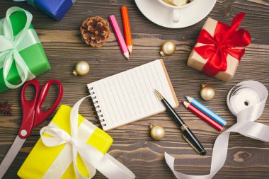 Yılbaşı tebrik kartları yazıyorum. Süslü ahşap masadaki kalemle birlikte defteri aç