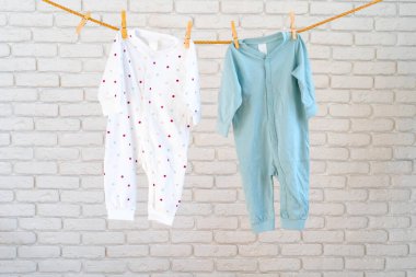 Kuruması için ipe iğnelenmiş bebek kıyafetlerinin yıkanması.