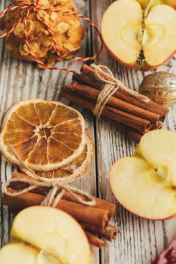 Tarçın çubukları ve süslemeleri olan eski ahşap arka planda yulaf ezmeli kurabiyeler.