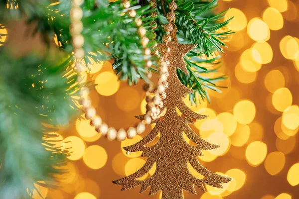 Decorazione di Natale appeso su un ramo di abete contro le luci di Natale — Foto Stock