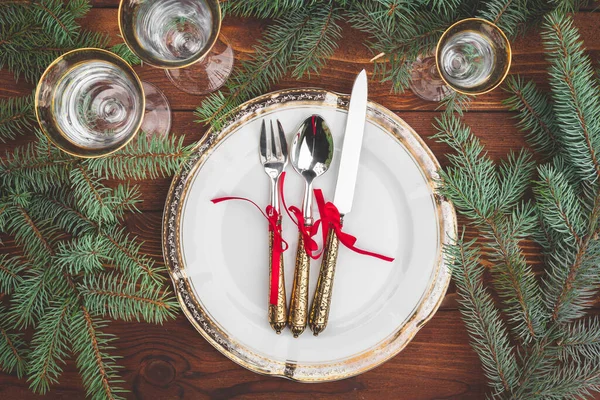 Çam ağacı dalları ve süslemeleri olan bir Noel masası.