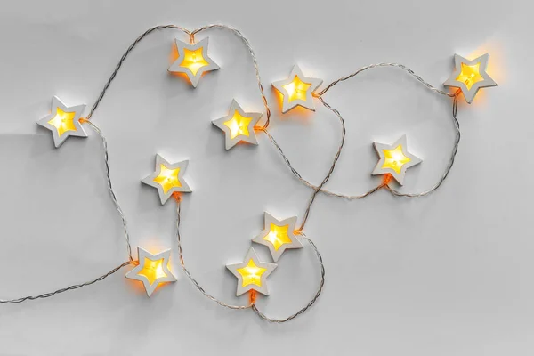 Beleuchtete sternförmige Girlande auf hellgrauem Hintergrund — Stockfoto