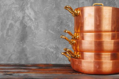 Ahşap masada bakır tencere yığını. Yakın çekim.