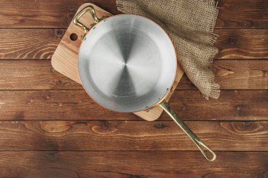 Ahşap tahtada temiz bakır mutfak malzemeleri.