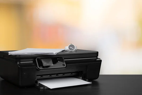 Impresora láser compacta sobre escritorio negro sobre fondo borroso —  Fotos de Stock