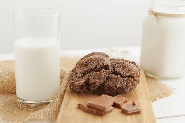 Milchglas und Kekskekse mit Küchentuch auf hellem Hintergrund — Stockfoto