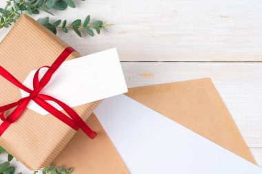 Ahşap arka planda küçük hediyeli boş Xmas istek listesi