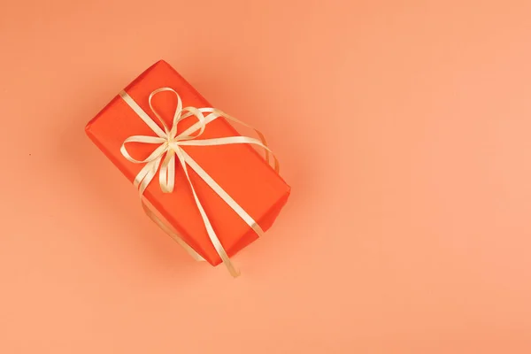 Present with a bow on orange background — Stock Photo, Image