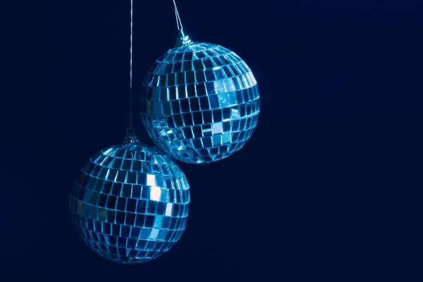 Ігристі диско-кулі висять у повітрі на чорному тлі — стокове фото