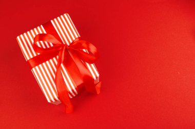 Kırmızı arka planda paketlenmiş hediye kutusu, yukarıdan görünüm